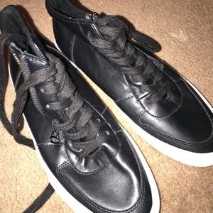 Black tennis shoes with white soles.
